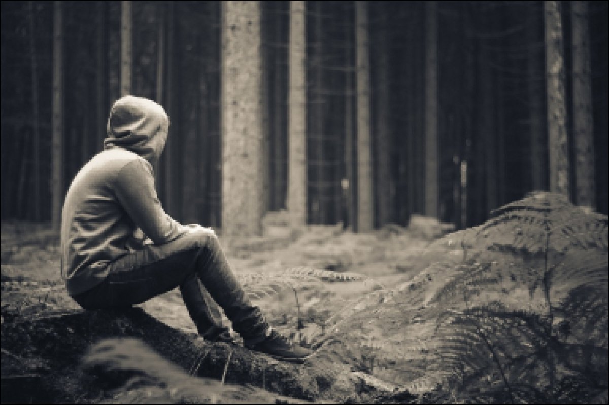 Парень в капюшоне сидит