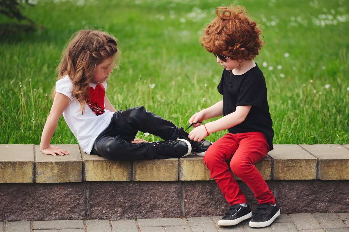 Мальчик помогает девочке одеться