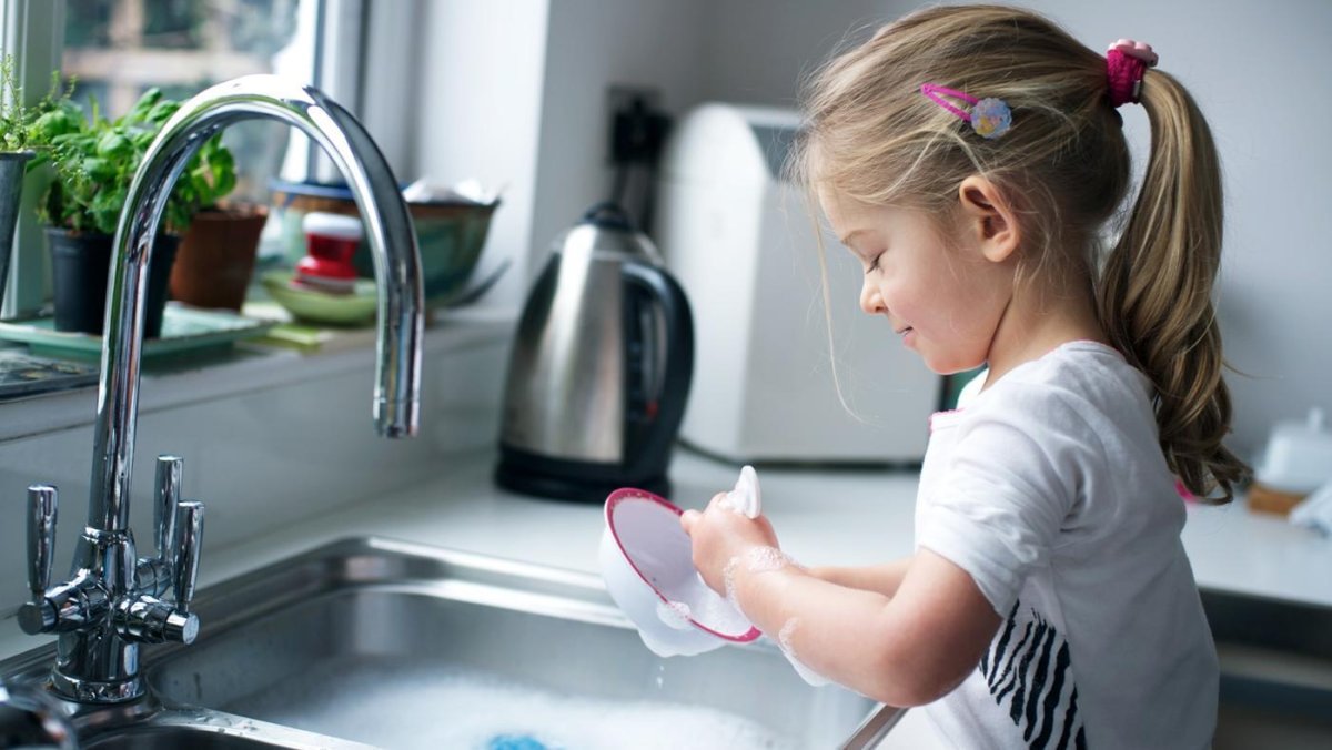 Девочка моет посуду